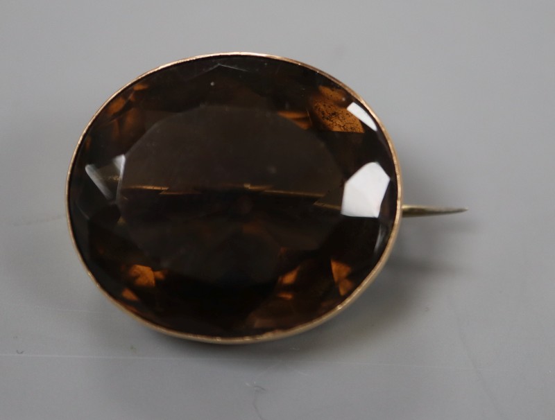 An early 20th century 15ct mounted oval brown quartz brooch, 25mm, gross weight 10.6 grams.